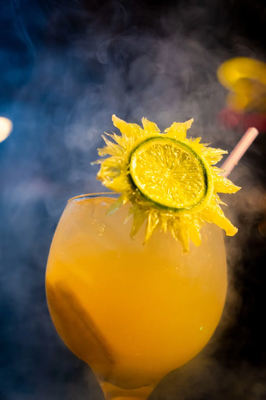 Drink amarelo com decoração cítrica e efeito de fumaça
